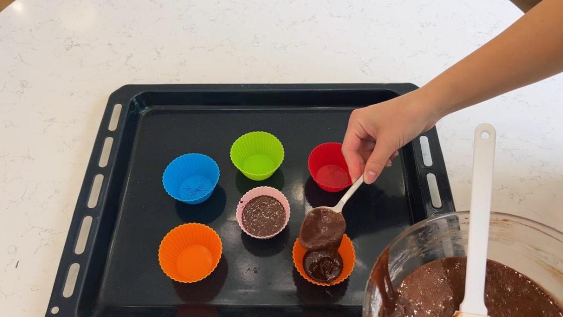 Шоколадное тесто перекладывают в формы для кексов