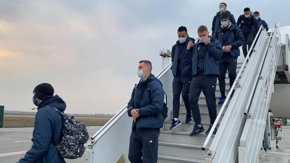 Игроки сборной Казахстана по футболу спускаются по трапу самолета