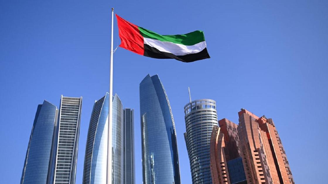 Флаг ОАЭ и вид на Абу-Даби