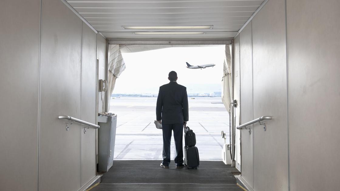Мужчина с багажом смотрит на самолет