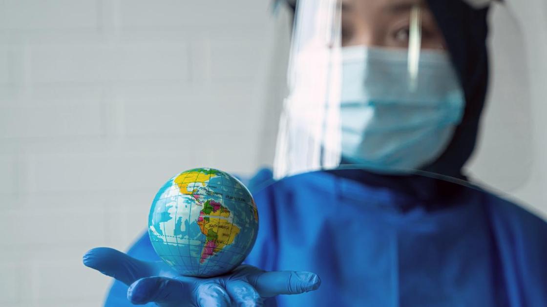 Медик держит в руке макет земного шара