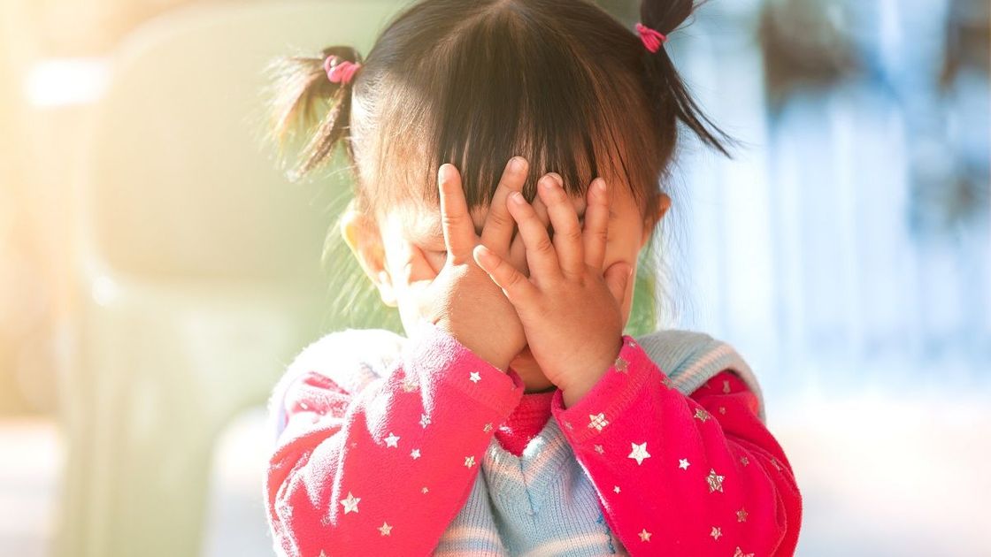 Маленькая девочка закрыла лицо руками