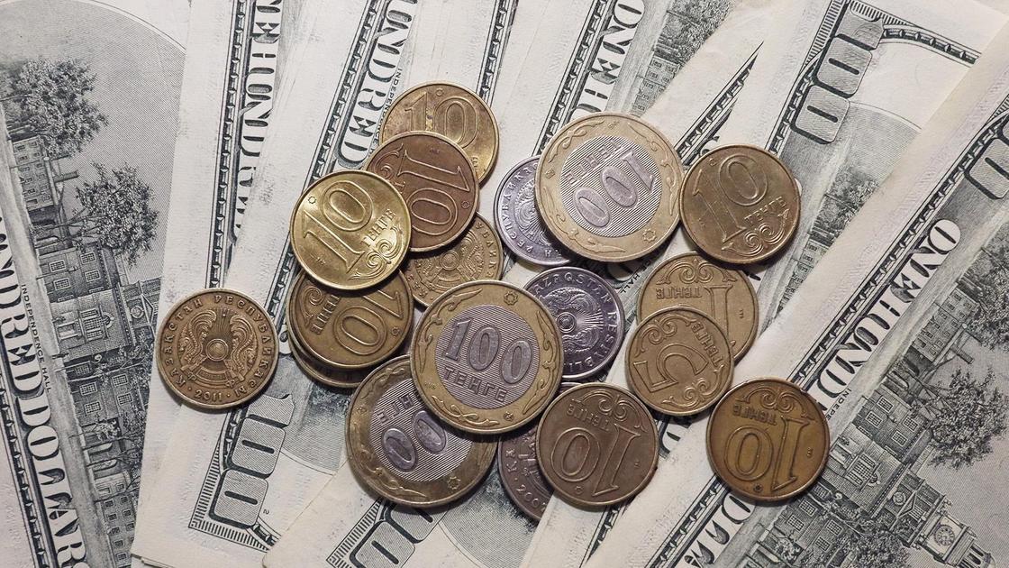 Монеты тенге лежат на долларах
