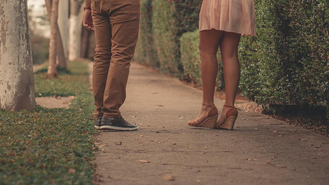 Девушка и парень стоят на тротуаре