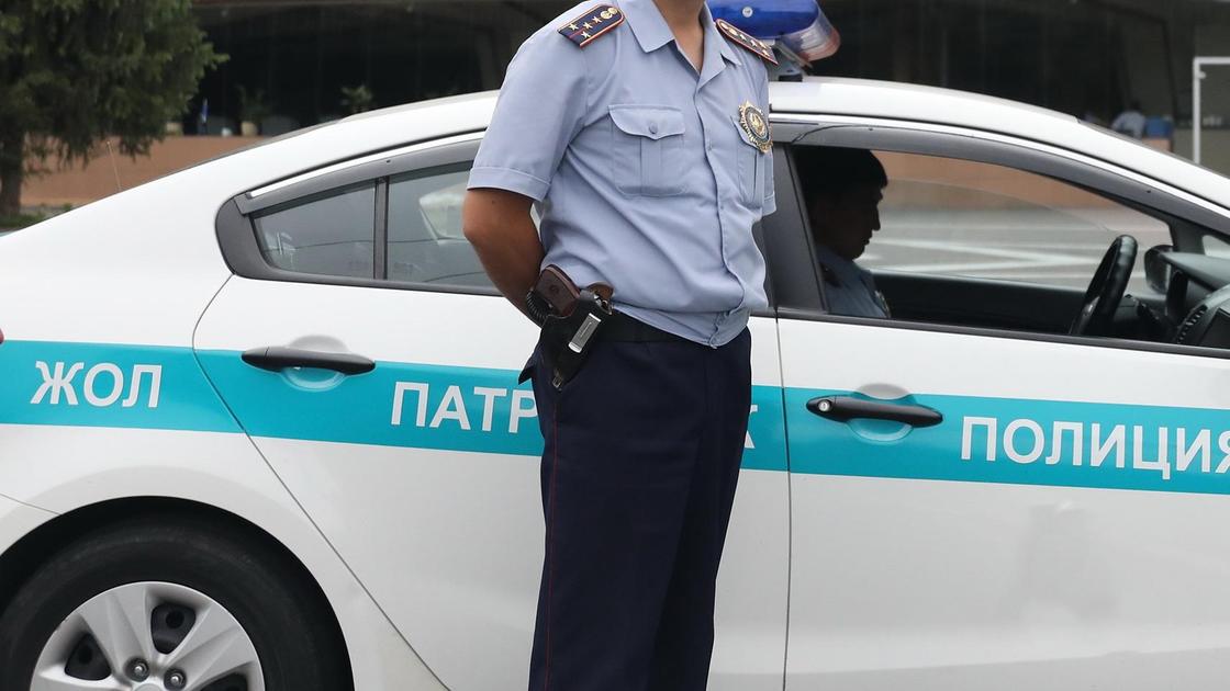 Полицейский стоит возле автомобиля