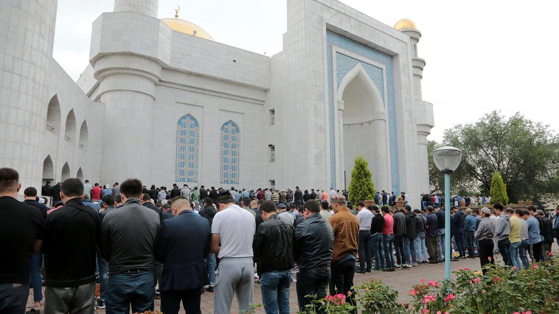 люди стоят возле мечети