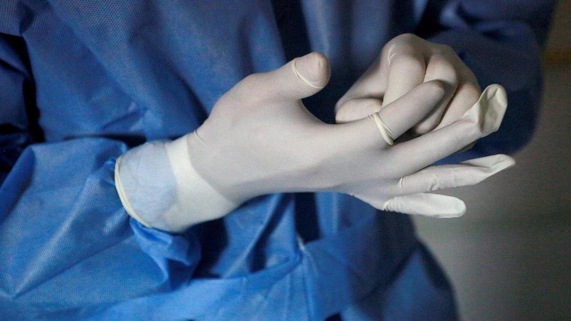Врач снимает перчатку Врач снимает перчатку
