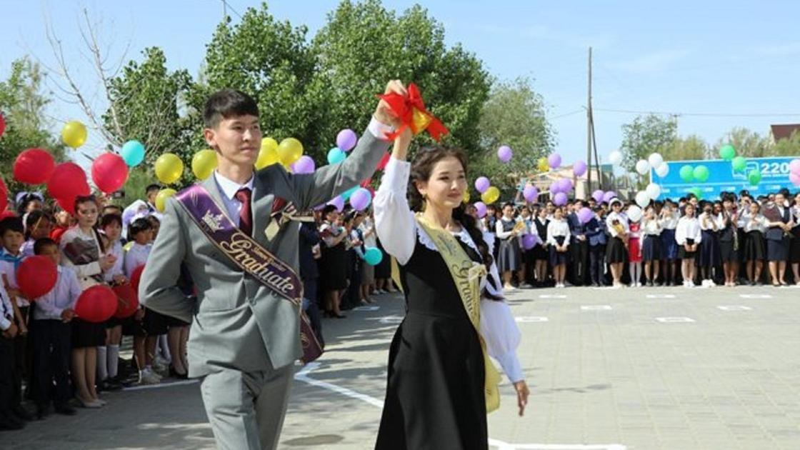 Қоңырау ұстаған түлектер