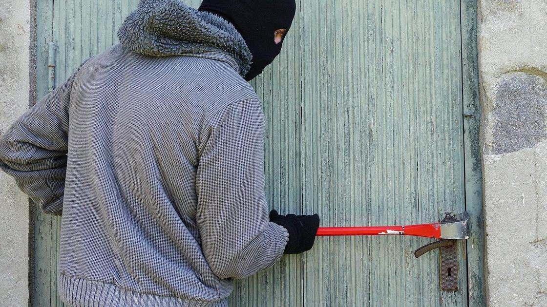 Вор взламывает дверь Вор взламывает дверь