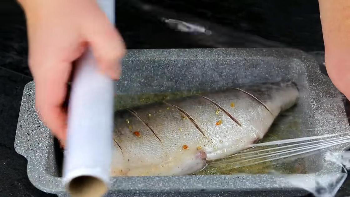 Замаринованная рыба в гастроемкости, обмотанной пищевой пленкой