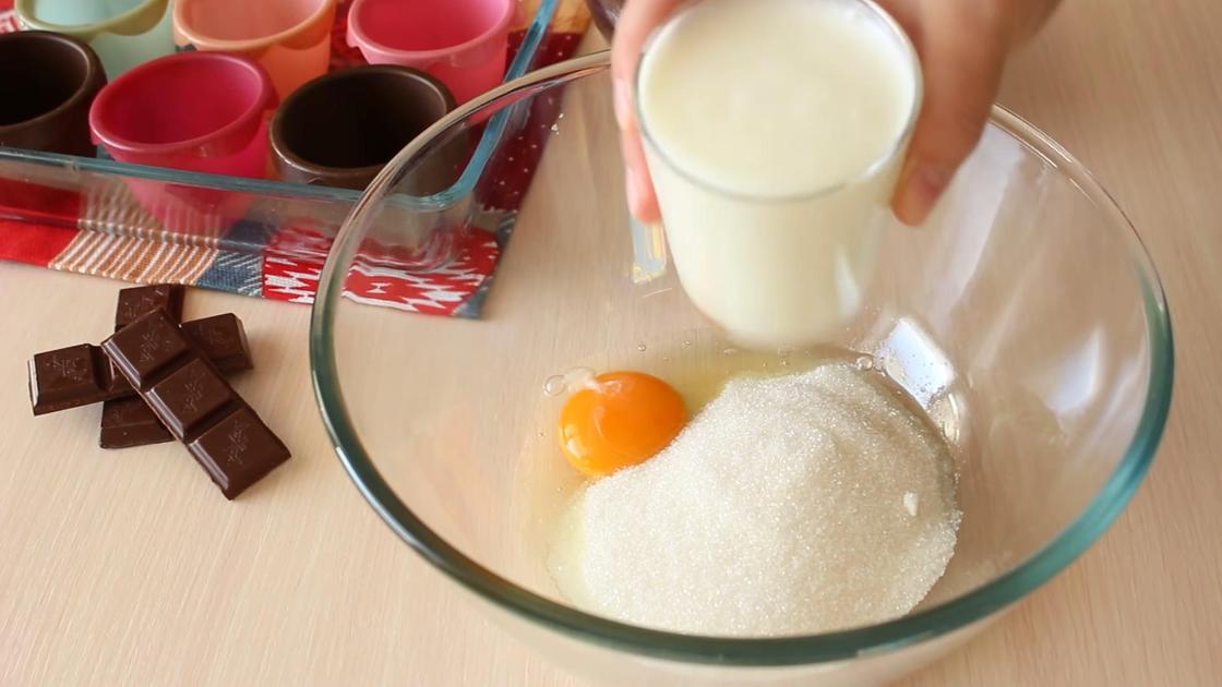 Кефир наливают из стакана в миску с яйцом и сахаром