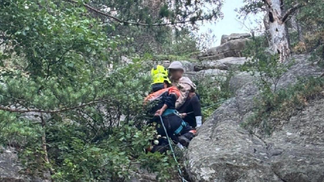 Спасатель спускается на веревке с ребенком