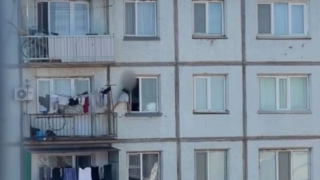 Девочка перелезает с балкона на окно