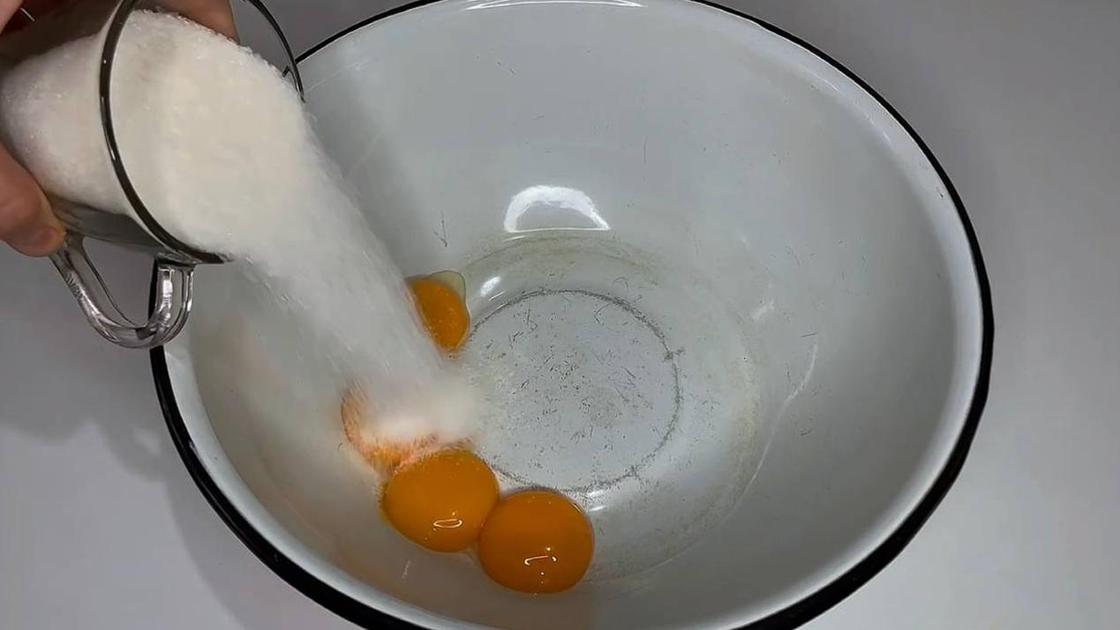 В миску с желтками насыпают сахар