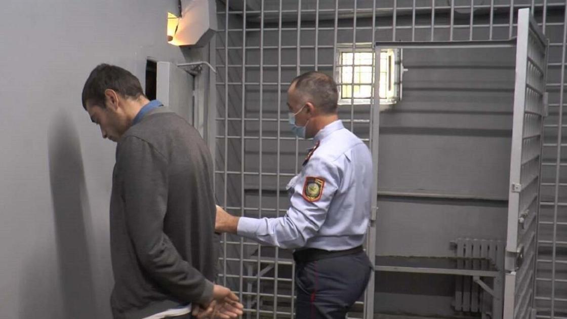 задержанный мужчина стоит перед камерой