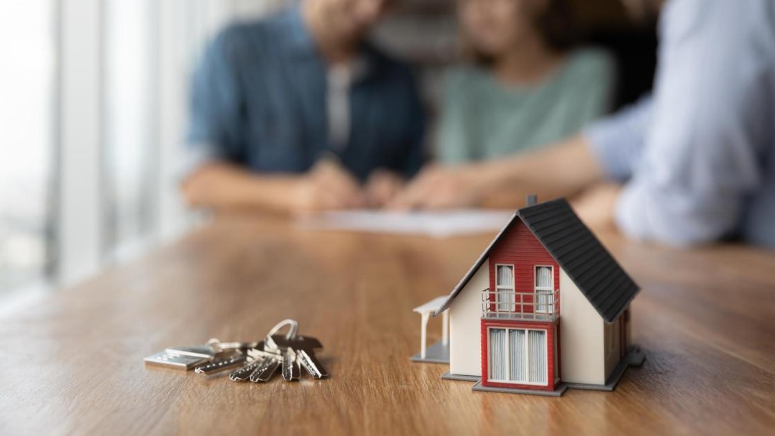 молодая семья подписывает договор об оформлении ипотеки