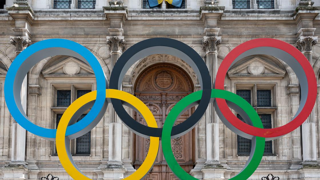 Олимпийские кольца на фоне здания в Париже