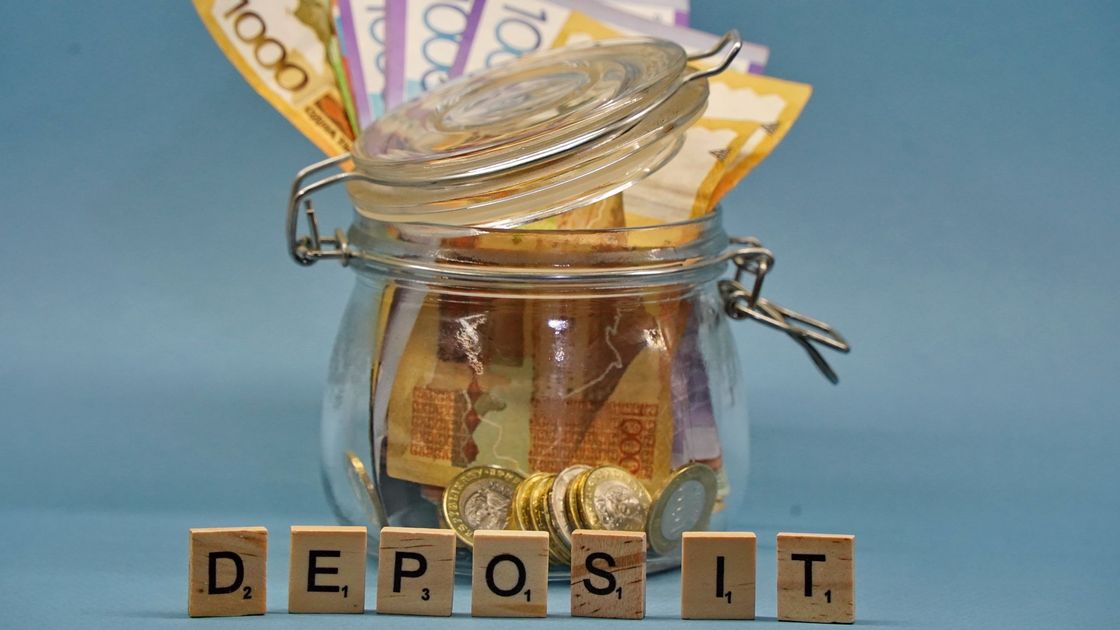 Деньги в банке и слово "Deposit", выложеное кубиками