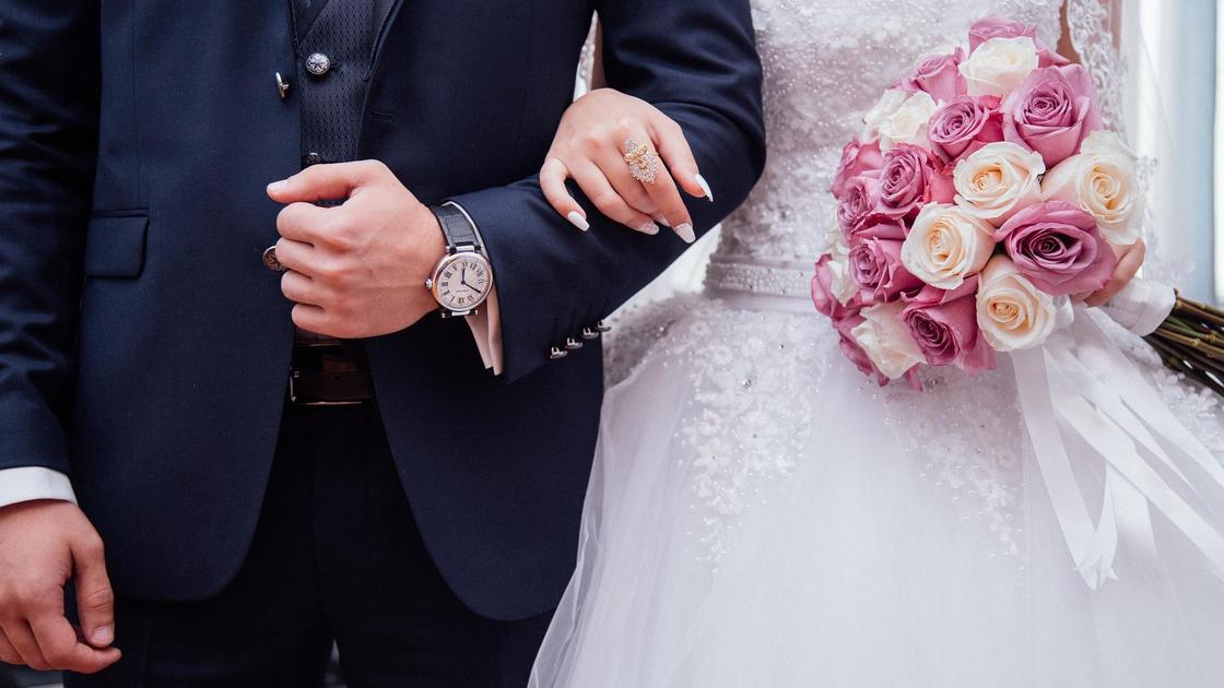 Невеста держит под руку жениха