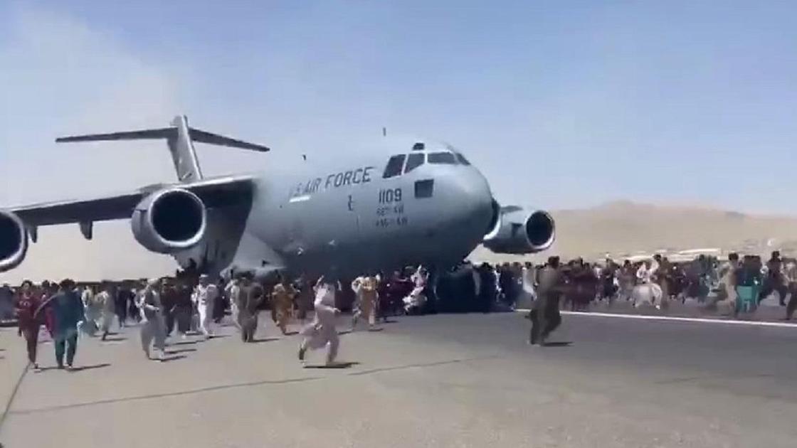 Люди бегут за взлетающим самолетом в Кабуле