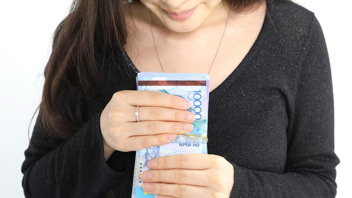 женщина держит в руках пачку денег женщина держит в руках пачку денег