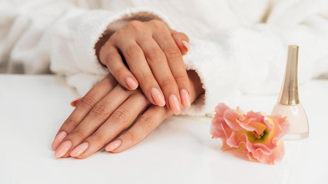 Красивые ухоженные женские руки с нежным розовым маникюром