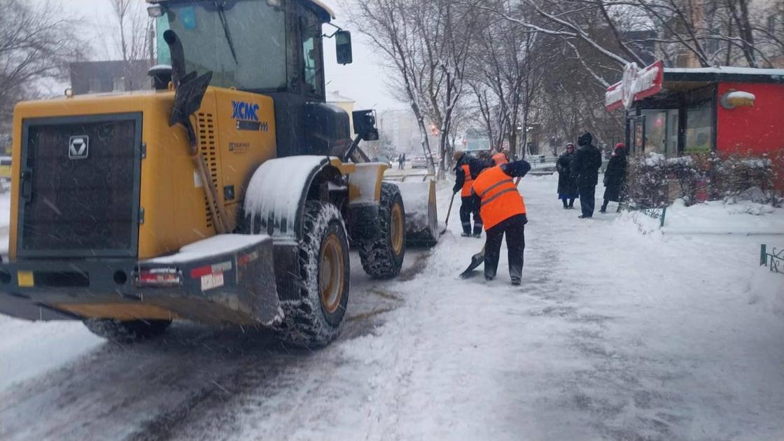 Сотрудники коммунальной службы за чисткой снега