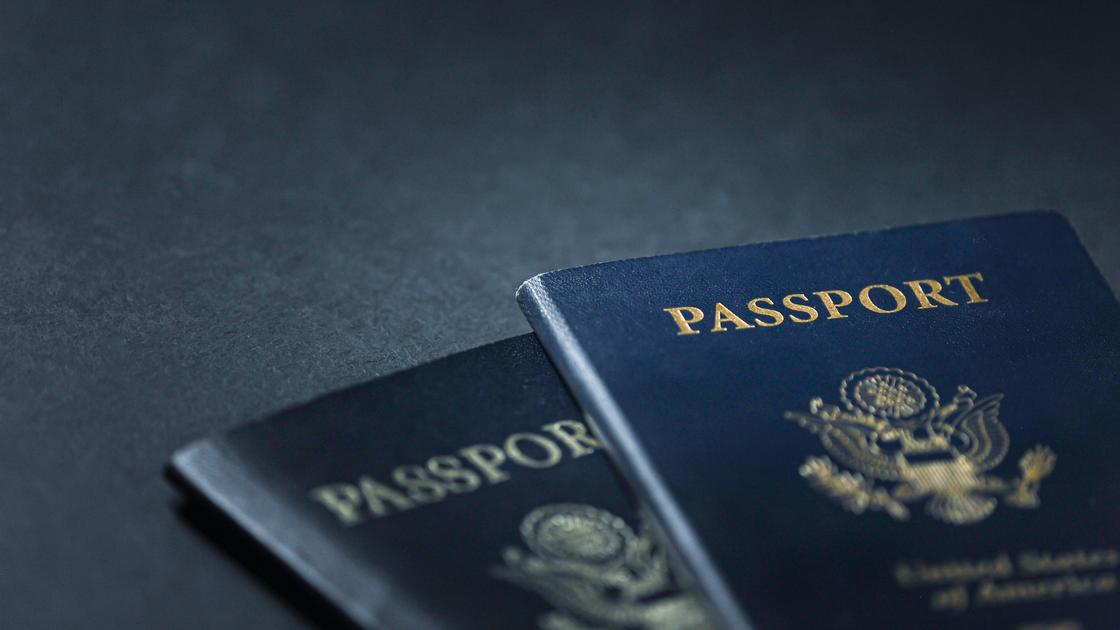 Два паспорта лежат на темной поверхности