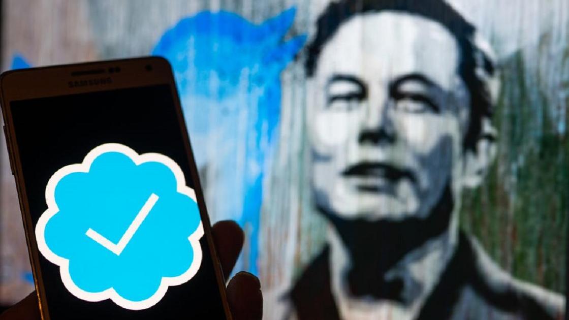 Синяя галочка верификации Twitter на фоне изображения Илона Маска
