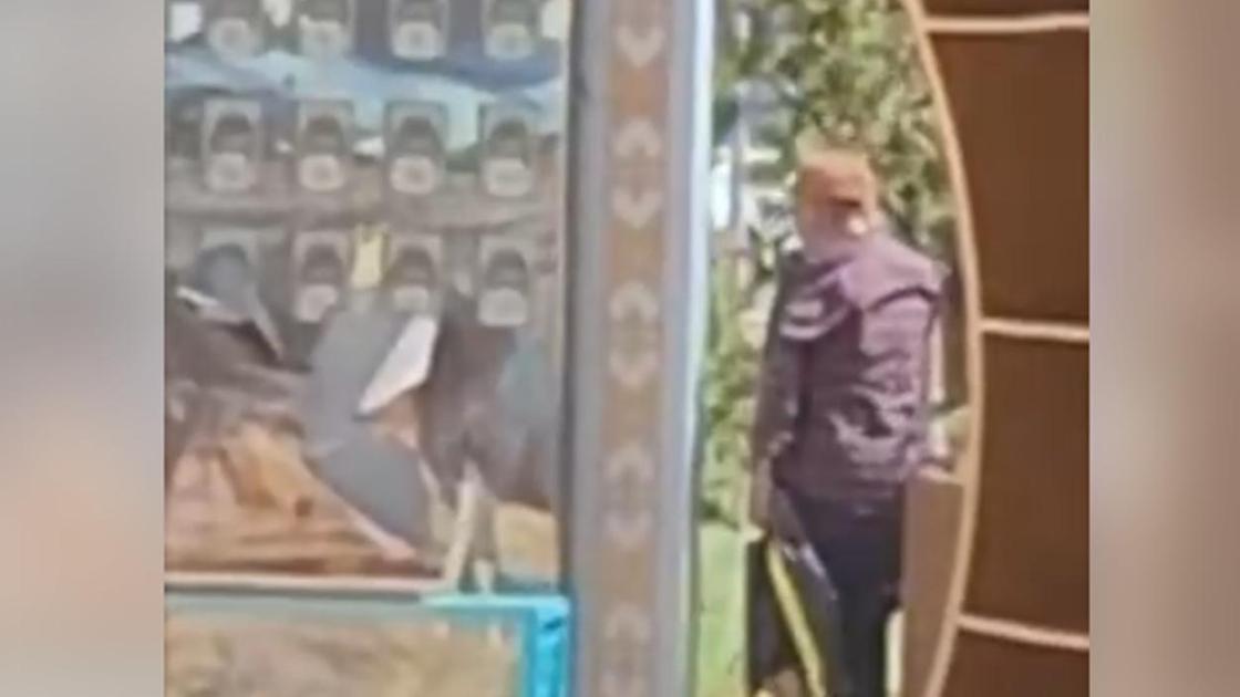 Стендті бүлдіріп жатқан ер адам