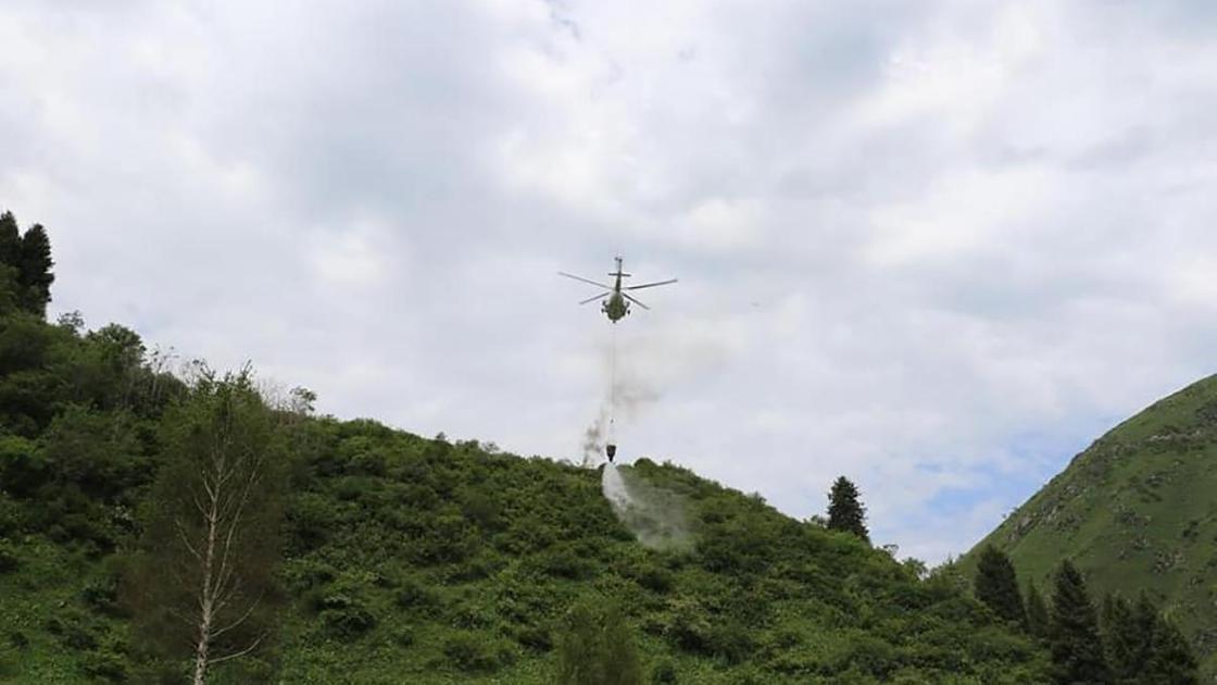 Вертолет летит над горами
