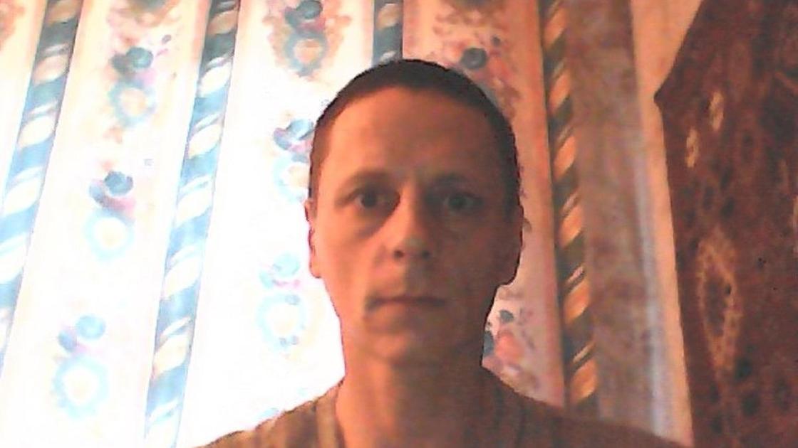 Подозреваемый Виталий Молчанов на фоне штор