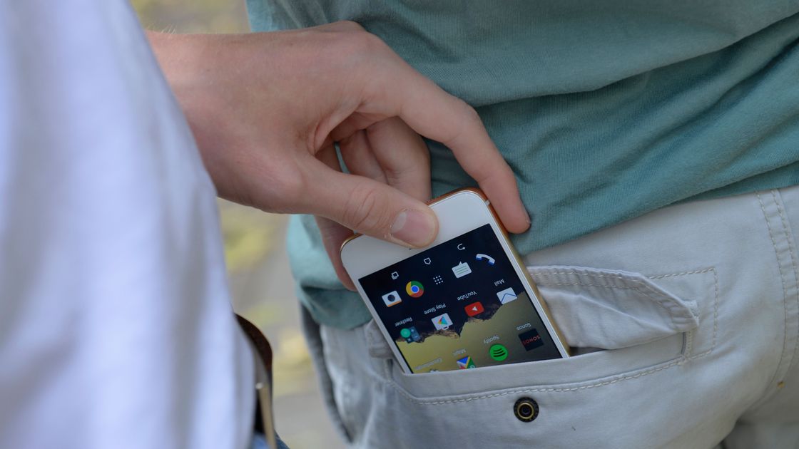 Человек достает телефон из кармана