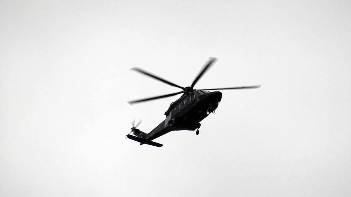 Черный вертолет на фоне пасмурного неба
