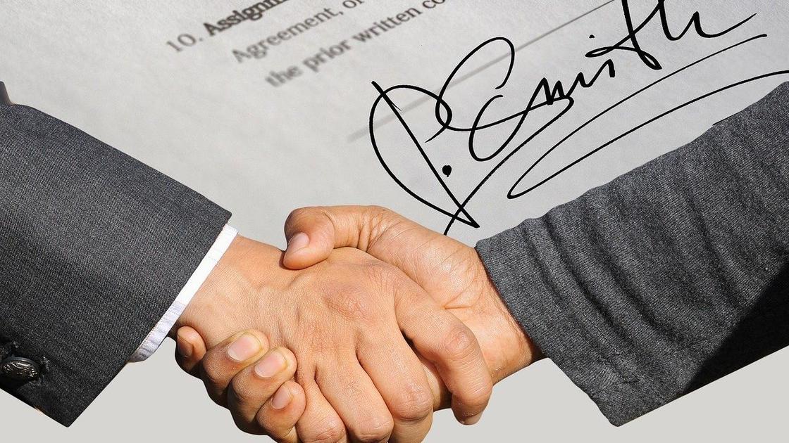 Подпись договора и рукопожатие Подпись договора и рукопожатие