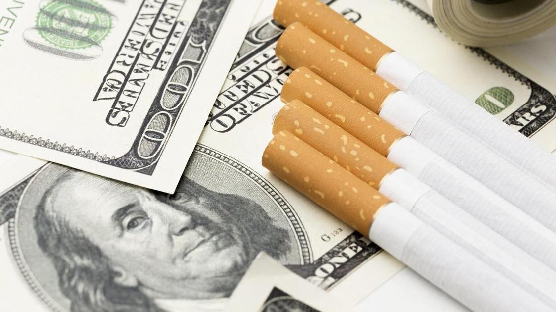 Сигареты лежат на долларовой купюре
