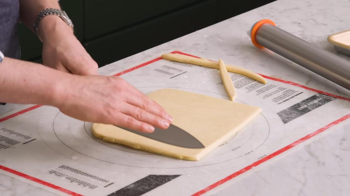 Слоеное тесто нарезают ножом