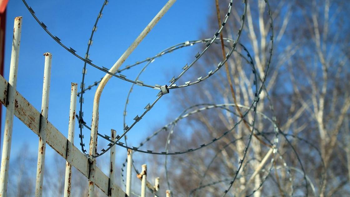 Колючая проволока на заборе тюрьмы Колючая проволока на заборе тюрьмы