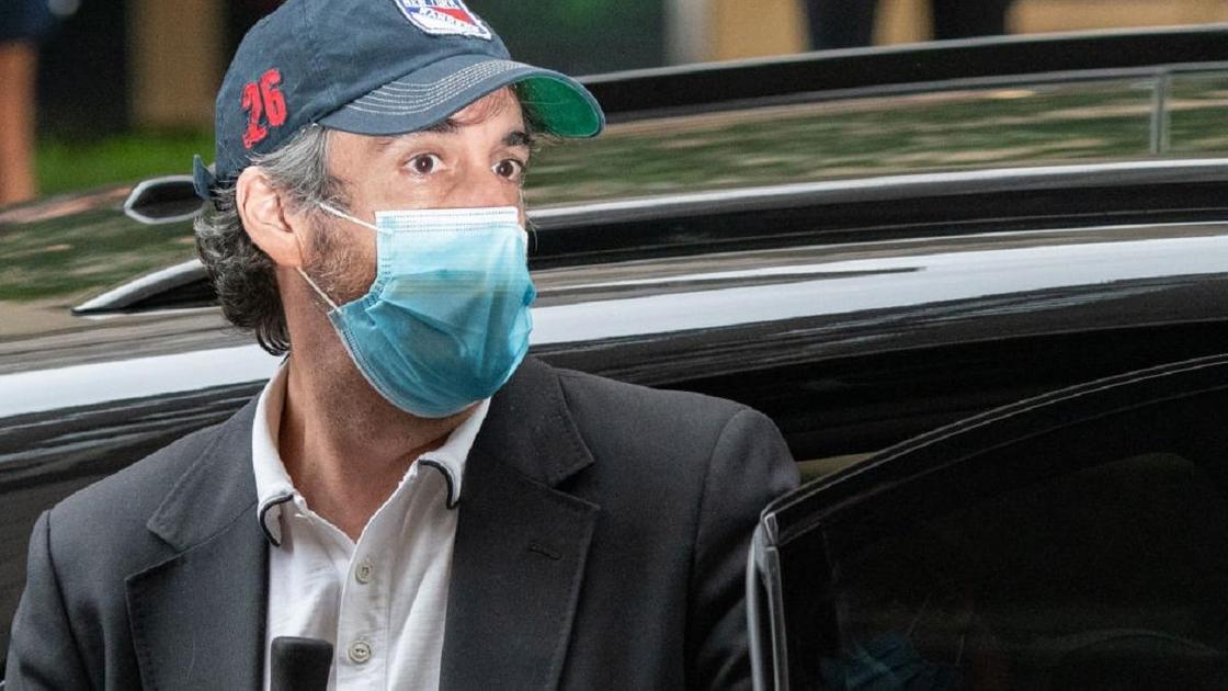 Майкл Коэн в кепке и медицинской маске выходит из машины