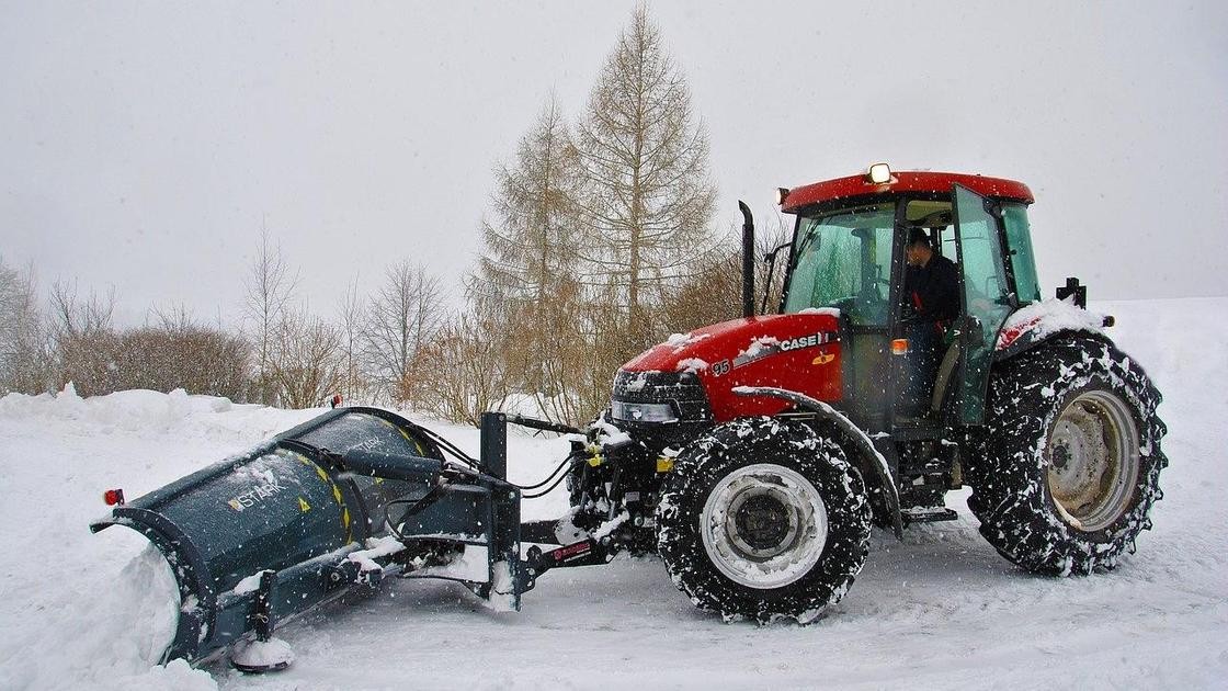 Трактор сгребает снег