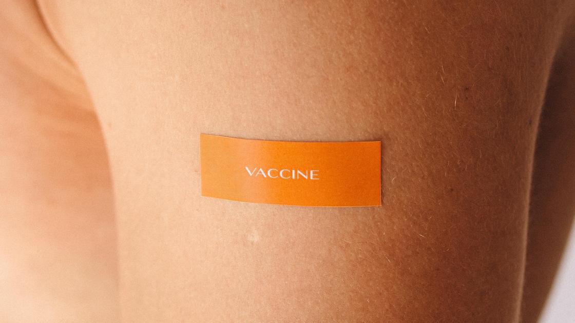 Рука с наклейкой "вакцина"