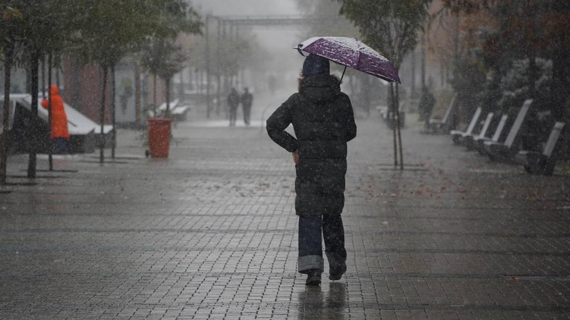 Девушка с зонтом идет по улице
