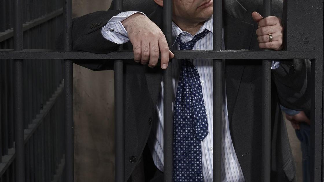 Человек в костюме за решеткой