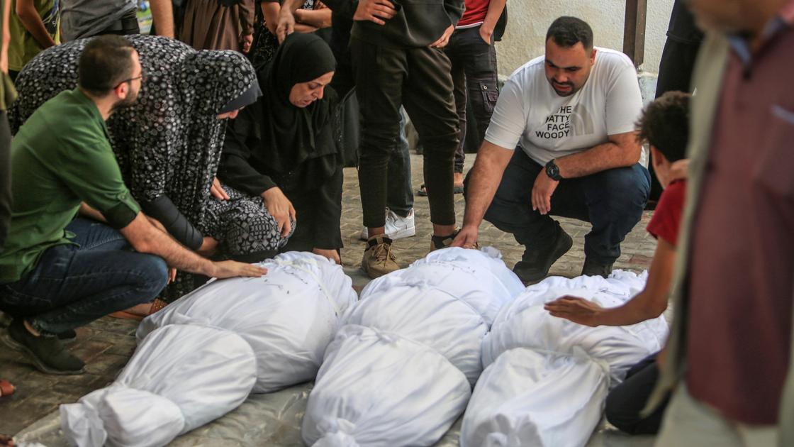 Люди рядом с телами погибших в секторе Газа