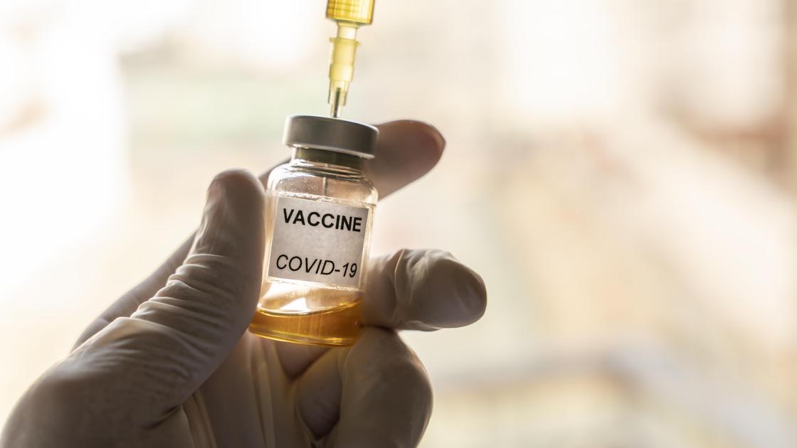 Медик набирает вещество из ампулы с вакциной от COVID-19