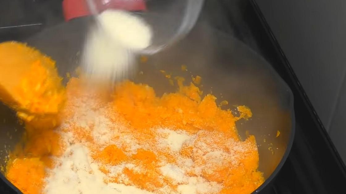 Добавление манки в кастрюлю с морковью