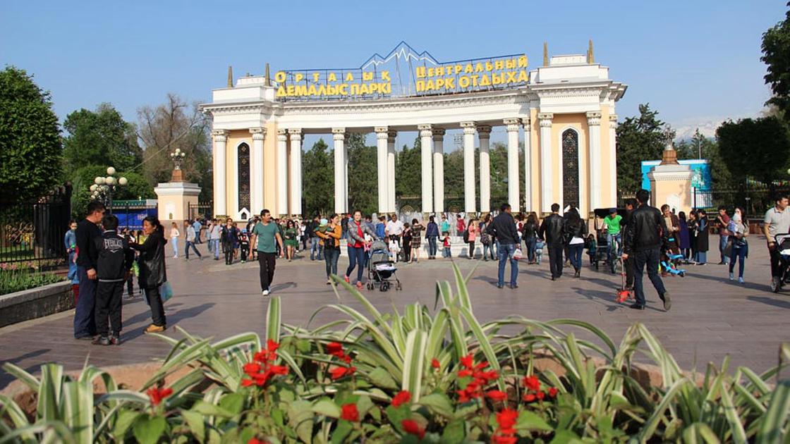 Люди гуляют возле Центрального парка культуры и отдыха Алматы