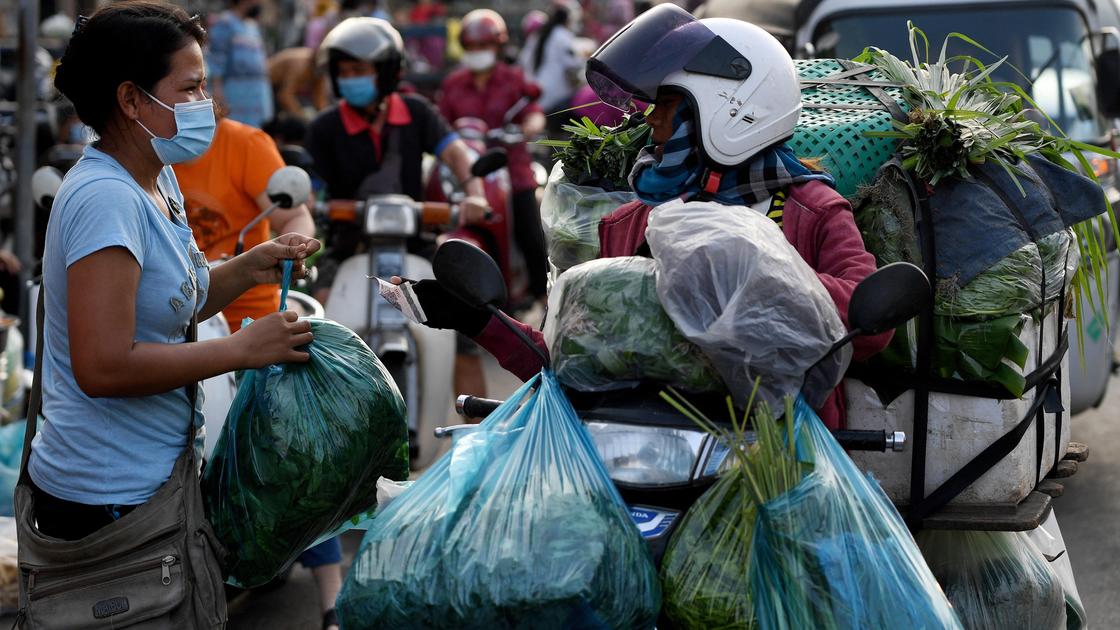 Женщина покупает зелень в Пномпене