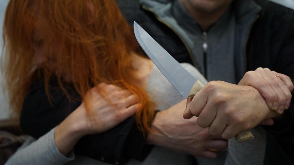 Мужчина замахивается с ножом на женщину