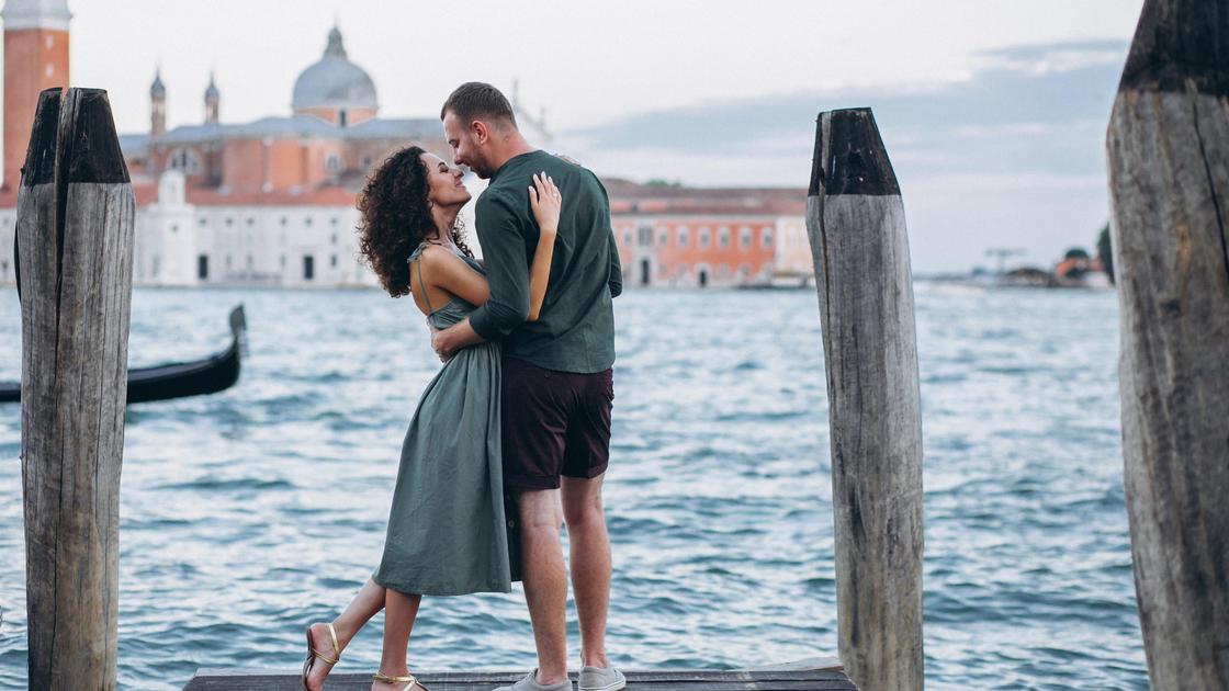Пара на деревянном мосту у канала в Венеции